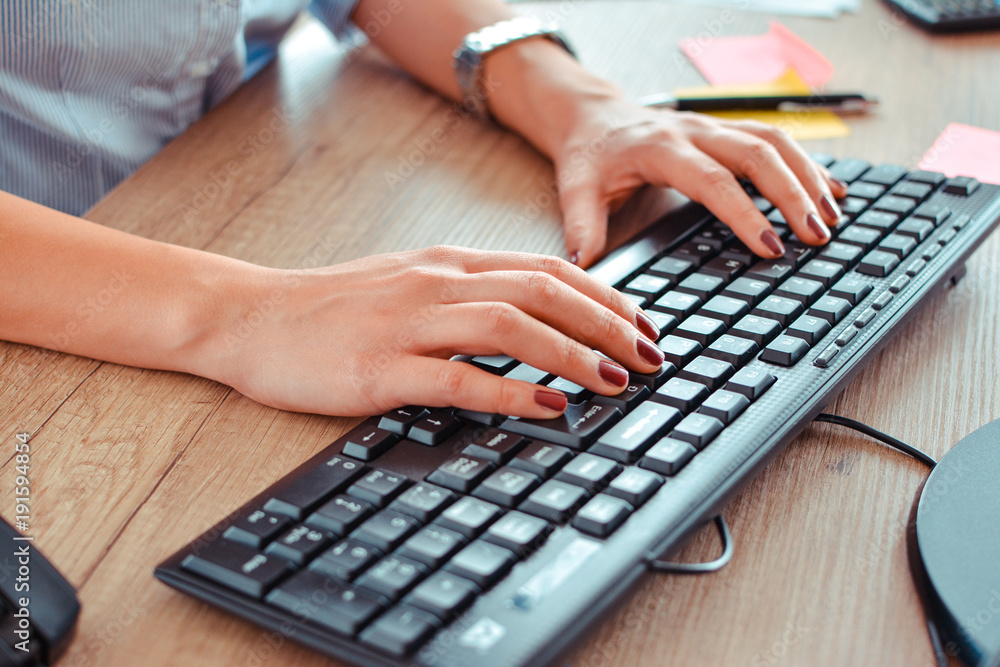 top view of the hands of a woman working with a laptop on a working desk top view of the hands of a woman working with a laptop on a working desk