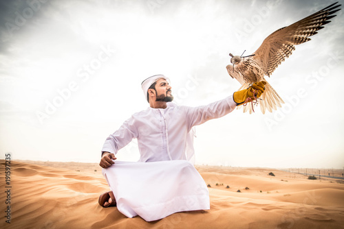 Vászonkép Arabic man in the desert with his hawk