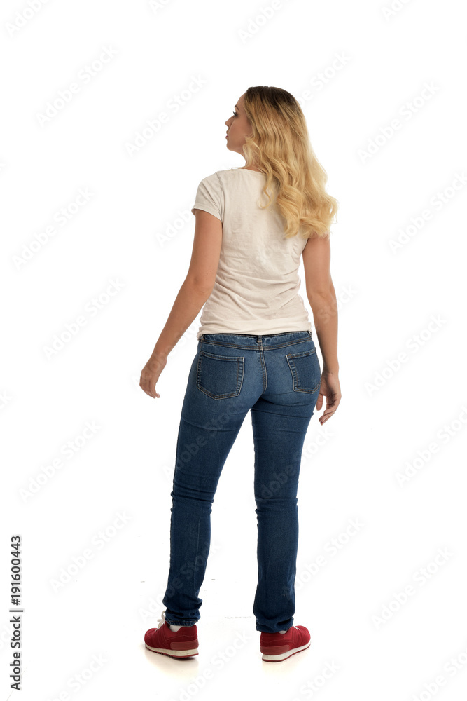 full length portrait of blonde lady wearing simple white shirt and jeans, standing pose isolated on white studio background. full length portrait of blonde lady wearing simple white shirt and jeans, standing pose isolated on white studio background.