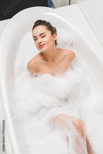 overhead view of beautiful young woman taking bath at home
