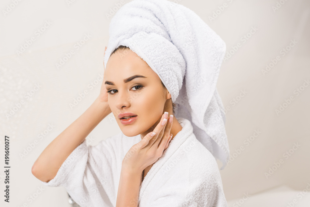 Obraz premium portrait of beautiful young woman in bathrobe with towel on head at home