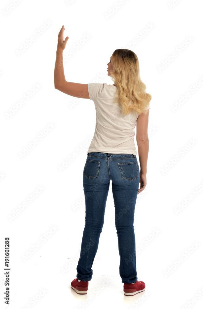 full length portrait of blonde lady wearing simple white shirt and jeans, standing pose isolated on white studio background. full length portrait of blonde lady wearing simple white shirt and jeans, standing pose isolated on white studio background.