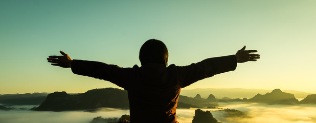 Man raised his arms to the mountains, freedom, success, thank God.