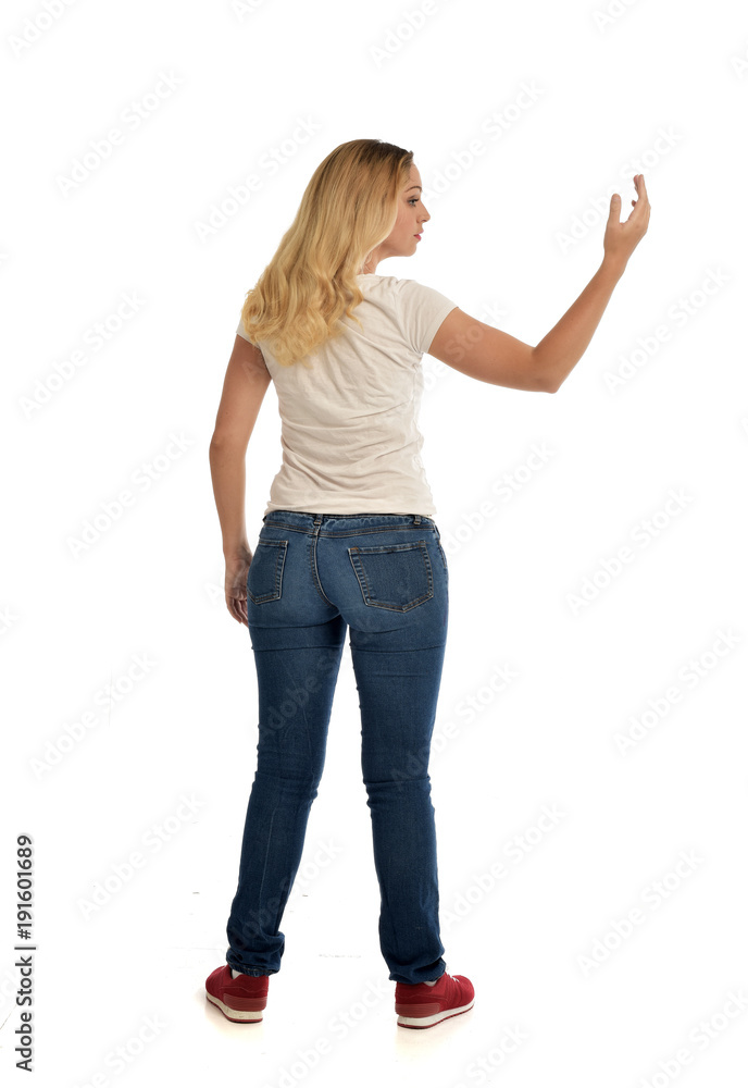 full length portrait of blonde lady wearing simple white shirt and jeans, standing pose isolated on white studio background. full length portrait of blonde lady wearing simple white shirt and jeans, standing pose isolated on white studio background.