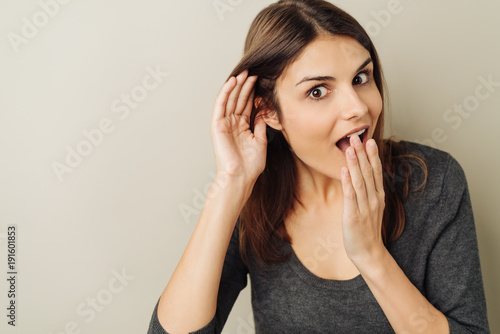 Astonished young woman listening to gossip