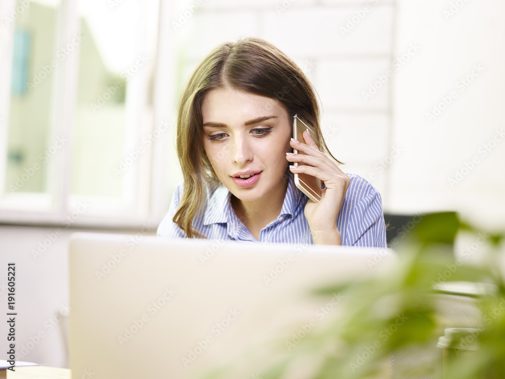 young caucasian corporate executive talking on cellphone in office young caucasian corporate executive talking on cellphone in office