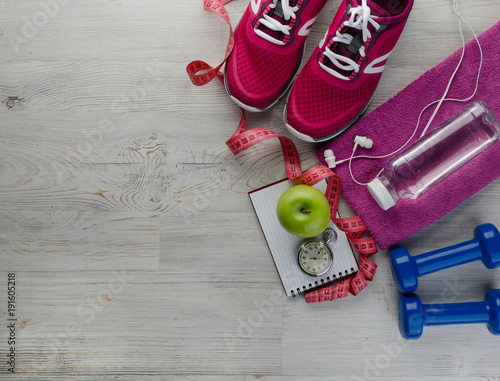 sneakers dumbbells bottle of water apple and measure tape