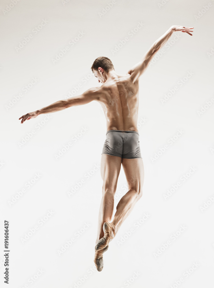 The male athletic ballet dancer performing dance isolated on white background. The male athletic ballet dancer performing dance isolated on white background.