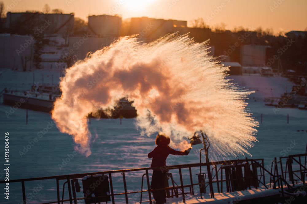 Insanely beautiful natural effect of turning boiling water into steam in the cold with a girl on a barge on a frozen river