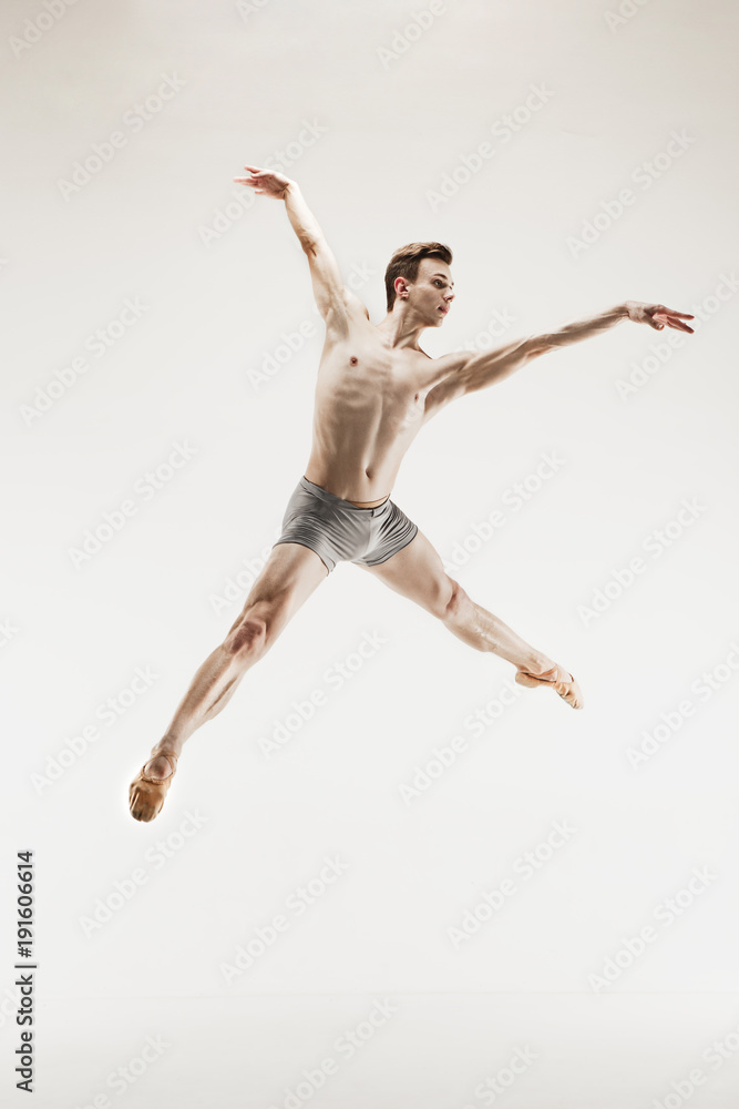 Fototapeta premium The male athletic ballet dancer performing dance isolated on white background.