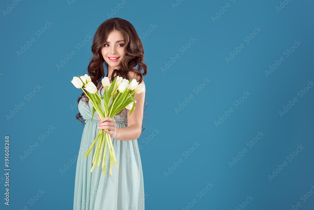 attractive girl showing bouquet of tulips isolated on blue attractive girl showing bouquet of tulips isolated on blue