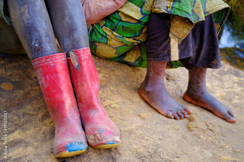 Feet and boots on dusty ground in Africa, Rwanda