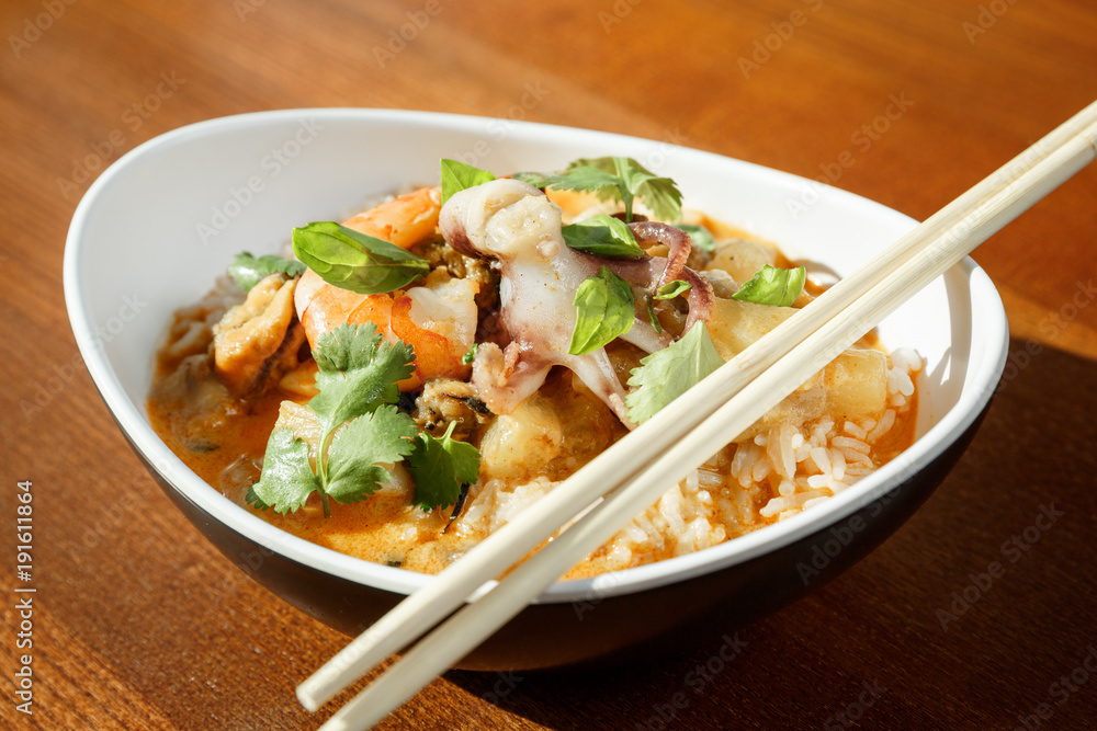 Asian riсe with seafood - shrimps and octopus -with sause in oval plate with bamboo sticks Asian riсe with seafood - shrimps and octopus -with sause in oval plate with bamboo sticks