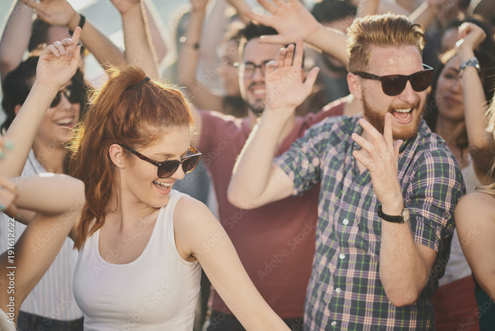 Group of people dancing and having a good time at the outdoor party/music festival Group of people dancing and having a good time at the outdoor party/music festival