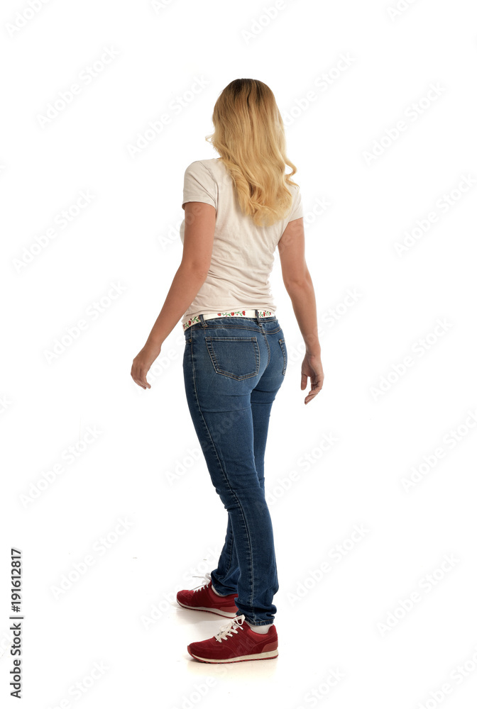 full length portrait of blonde girl wearing simple white shirt and jeans, standing pose, isolated on white studio background. full length portrait of blonde girl wearing simple white shirt and jeans, standing pose, isolated on white studio background.
