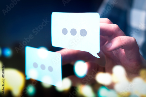 Communication, dialog, conversation on an online forum and internet chatting concept. Business man or social media consultant holding speech bubbles in futuristic modern abstract space. photo