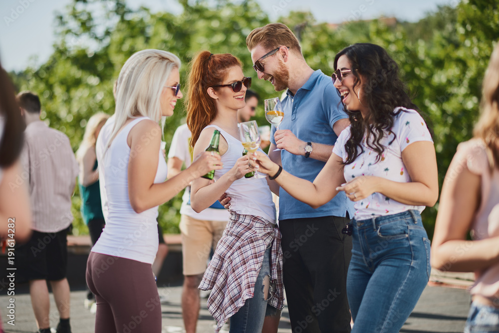 Group of people standing and drinking at the summer outdoor party Group of people standing and drinking at the summer outdoor party