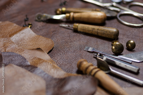 Furniture assembly components and tools, cow leather samples in the in the craftman's workshop.