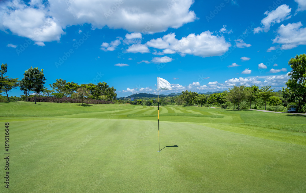 Obraz premium The White flag on hole of golf with blue could background