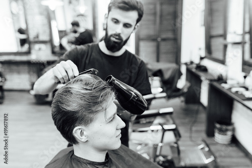 man getting trendy haircut at barber shop.