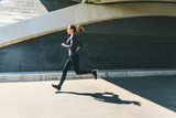 Woman jogging or running, side view with shadow