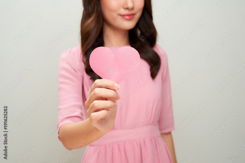 Beautiful asian woman smiling and showing pink heart shape. Loving concept. Beautiful asian woman smiling and showing pink heart shape. Loving concept.
