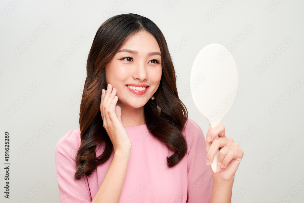 Asian woman looking at the mirror and touching on her skin. Asian woman looking at the mirror and touching on her skin.