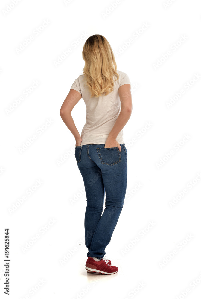 full length portrait of blonde girl wearing simple white shirt and jeans, standing pose, isolated on white studio background. full length portrait of blonde girl wearing simple white shirt and jeans, standing pose, isolated on white studio background.