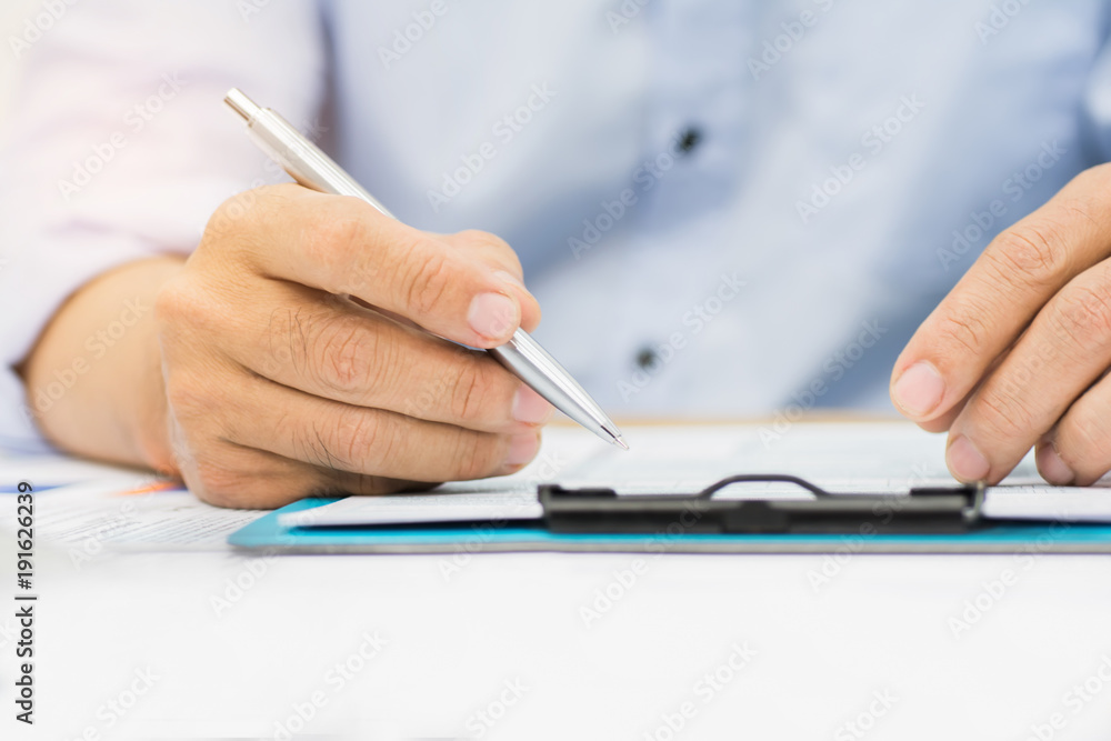 A man's hand holding pen pointing on summary report chart and calculate finance in office. A man's hand holding pen pointing on summary report chart and calculate finance in office.