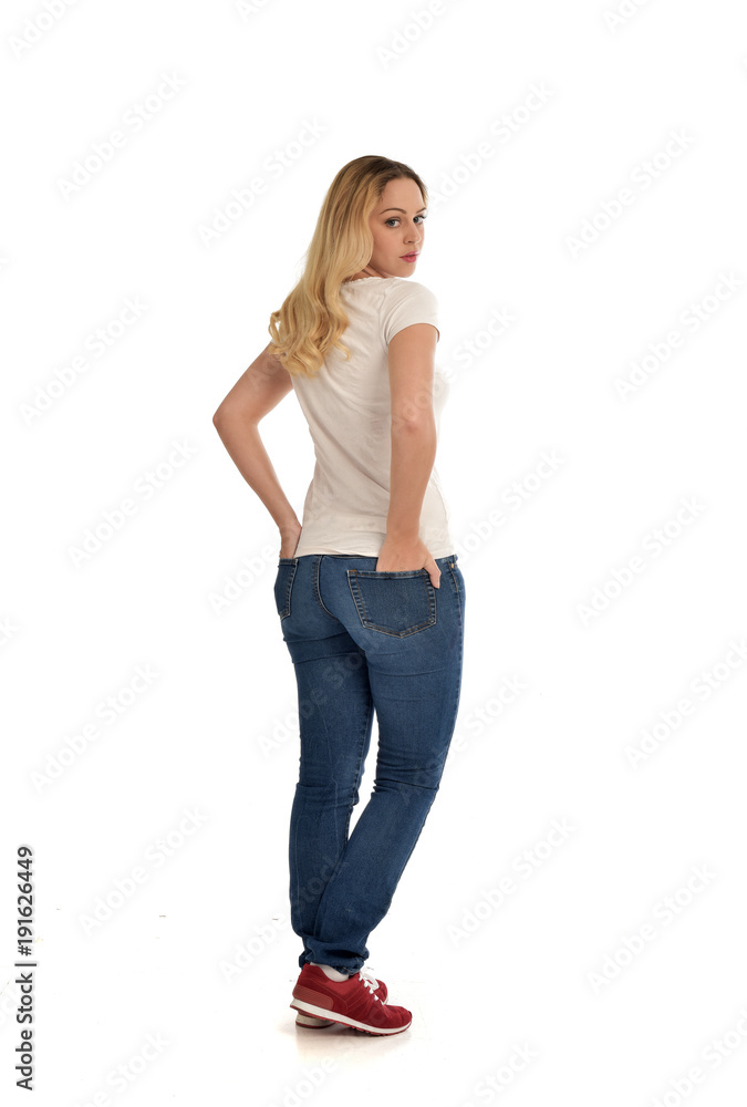 full length portrait of blonde girl wearing simple white shirt and jeans, standing pose, isolated on white studio background. full length portrait of blonde girl wearing simple white shirt and jeans, standing pose, isolated on white studio background.