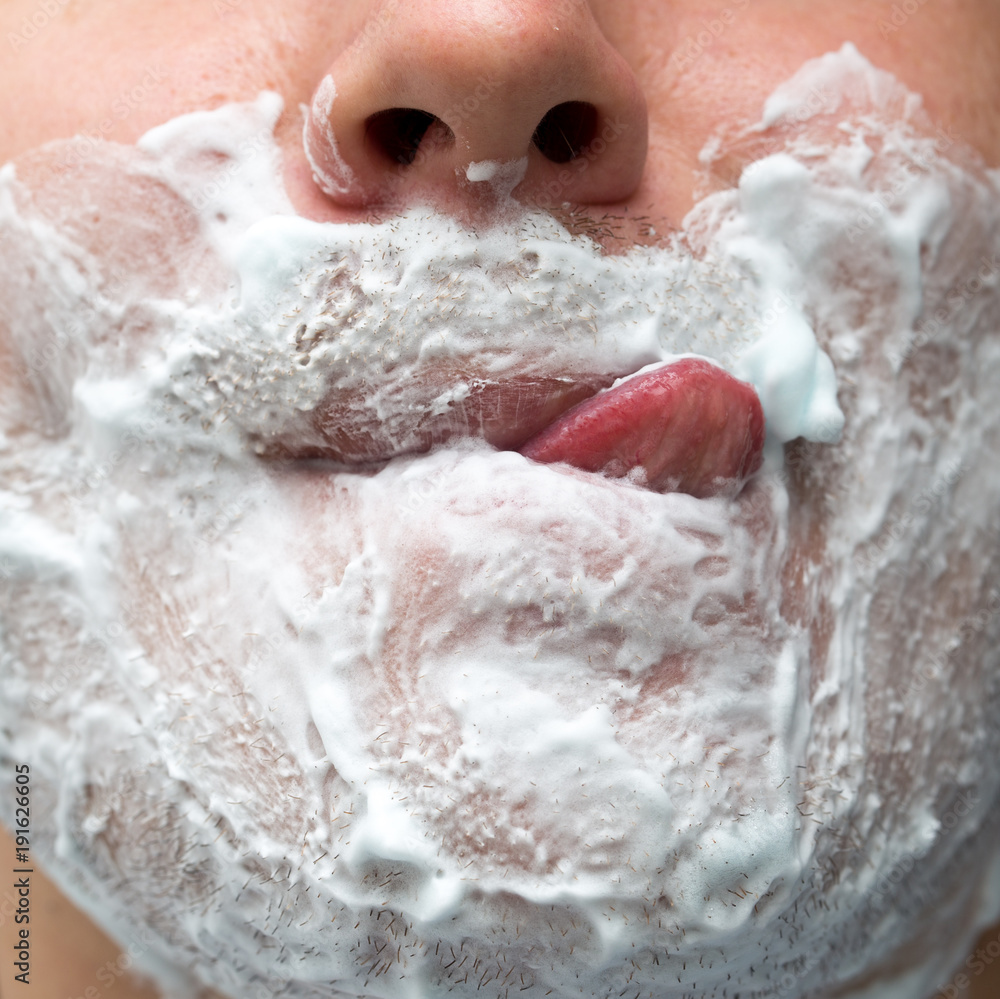 Fototapeta premium A man is applying face shaving foam
