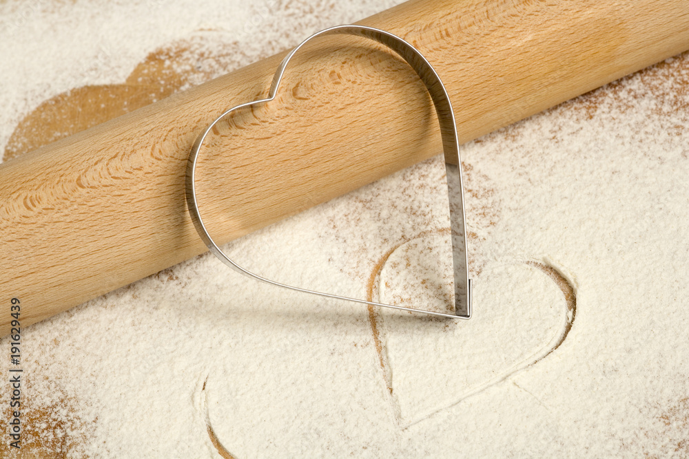 Flour, cookie cutters shaped as heart and rolling pin on a stone Stock  Photo by ©karidesign 107741166