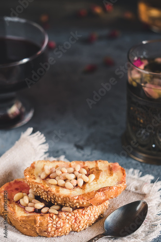Toasts of bread with sesame seeds homemade cake in stack decorated with pine nut linen cotton napkin © IRINA