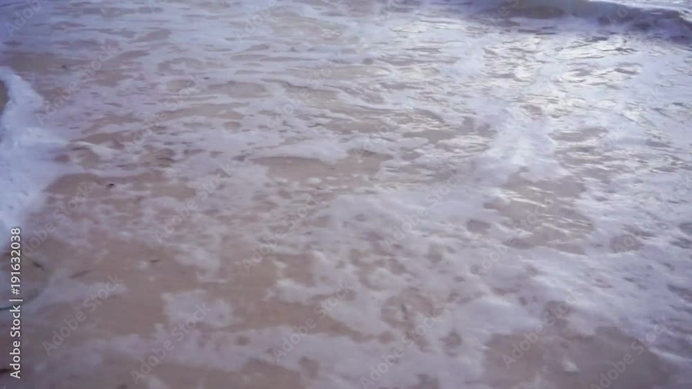 Close-up of human footprints in the wet sand at the seaside
