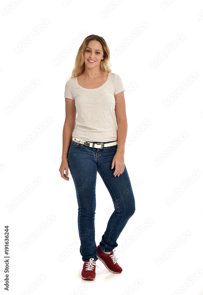 full length portrait of blonde girl wearing white shirt and jeans. standing pose, isolated on white studio background. full length portrait of blonde girl wearing white shirt and jeans. standing pose, isolated on white studio background.