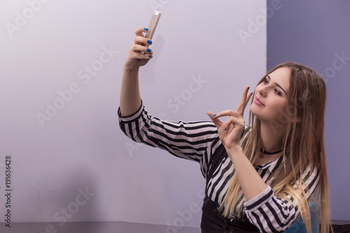 Young woman taking a selfie. Millenial. Copy space.