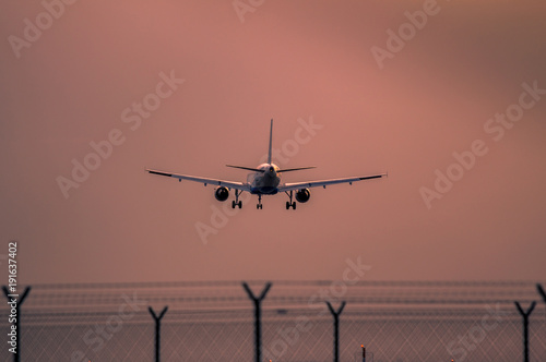 Airplane landing at sunset