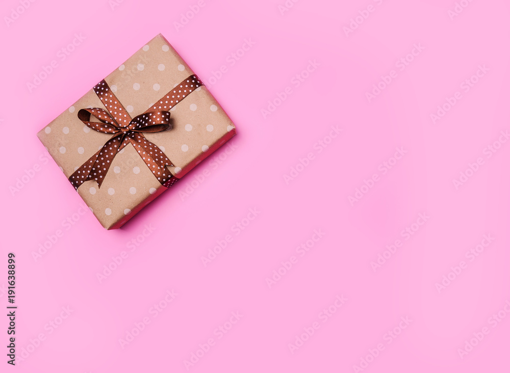 Craft paper wrapped present box craft rope on pink background, top view. Copyspace for your text. Craft paper wrapped present box craft rope on pink background, top view. Copyspace for your text.