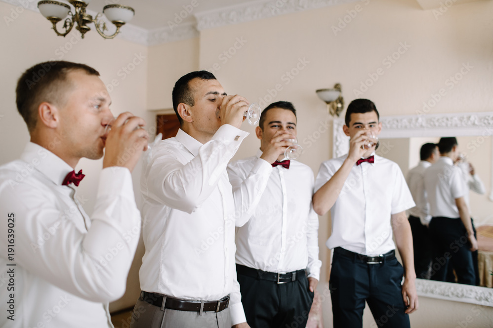 Obraz premium Handsome groom preparing for wedding ceremony in hotel room
