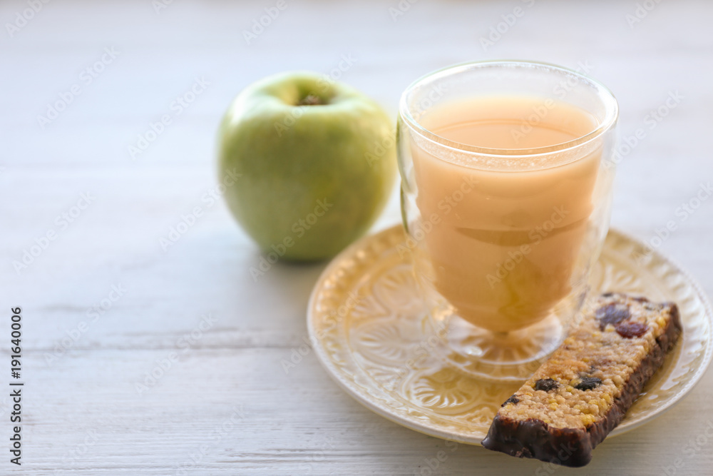 Glass of juice, cereal bar and apple on table. Tasty breakfast Glass of juice, cereal bar and apple on table. Tasty breakfast