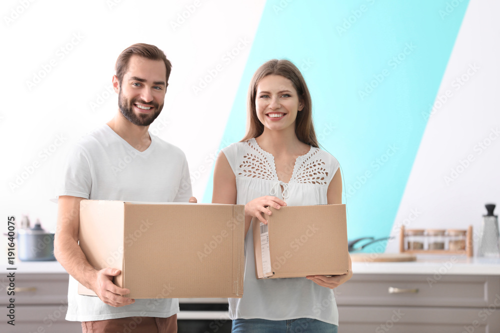 Young couple with boxes indoors. Moving day Young couple with boxes indoors. Moving day