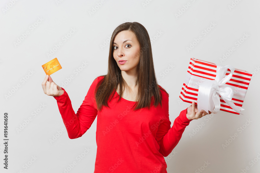 Beautiful woman holding credit card, red present box with gift isolated on white background. For advertisement. St. Valentine's Day, International Women's Day, Christmas, birthday, holiday concept. Beautiful woman holding credit card, red present box with gift isolated on white background. For advertisement. St. Valentine's Day, International Women's Day, Christmas, birthday, holiday concept.
