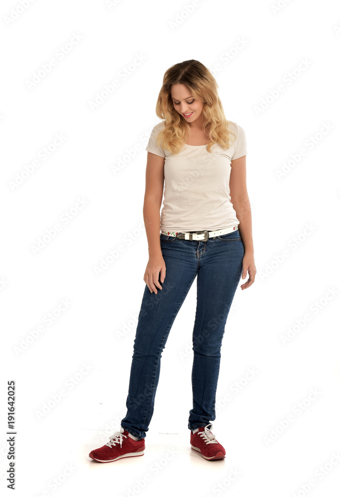 full length portrait of blonde girl wearing white shirt and jeans. standing pose, isolated on white studio background. full length portrait of blonde girl wearing white shirt and jeans. standing pose, isolated on white studio background.