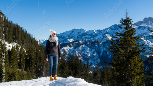 Junge attraktive Frau wandert in den Alpen durch den Schnee photo