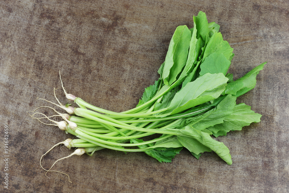 fresh turnip tops (turnip greens) on a grungy metal background fresh turnip tops (turnip greens) on a grungy metal background