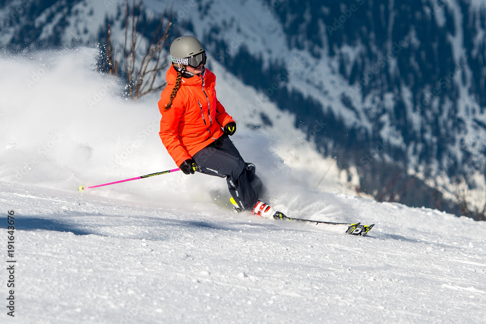 Junge Frau auf einer Skipiste bei der Abfahrt ins Tal Junge Frau auf einer Skipiste bei der Abfahrt ins Tal