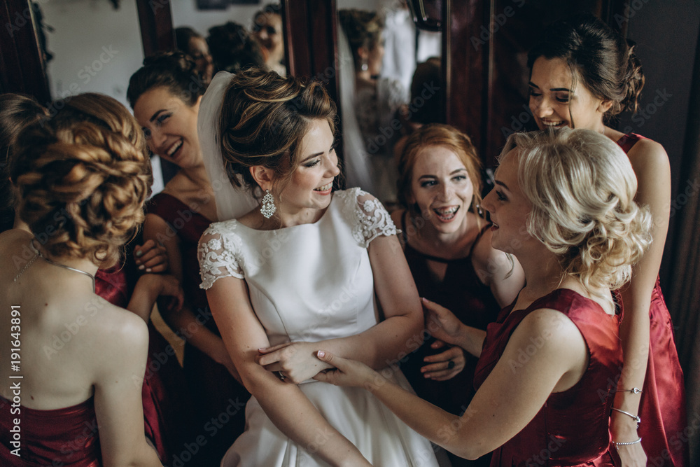 Obraz premium Lovely bride and bridesmaids next to the big window