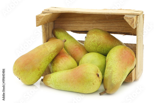 fresh juicy abate pears in a wooden box on a white background
