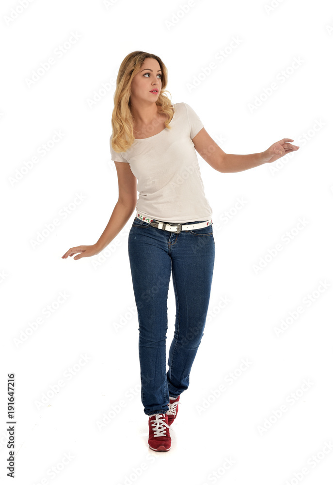full length portrait of blonde girl wearing white shirt and jeans. standing pose, isolated on white studio background. full length portrait of blonde girl wearing white shirt and jeans. standing pose, isolated on white studio background.