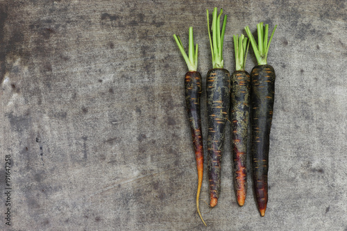 black carrots on a grungy metal background